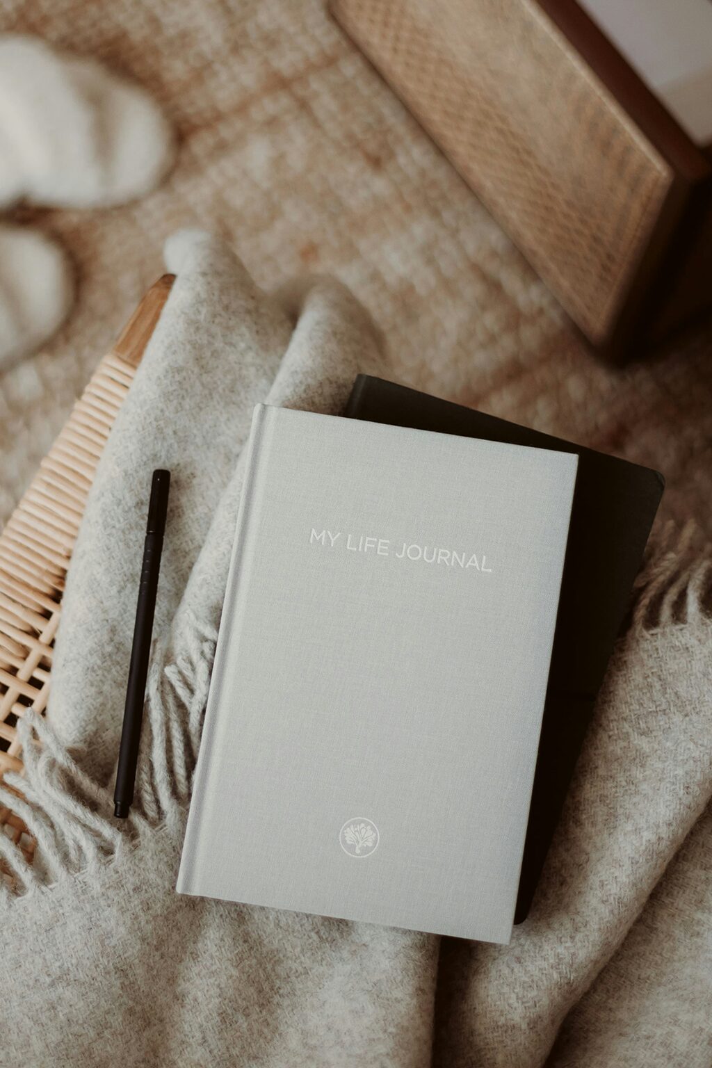 A linen-bound “My Life Journal” resting on a blanket with a pen, symbolizing introspection and recovery-focused journaling.